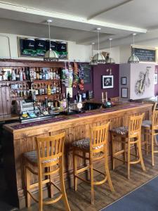 a bar with wooden chairs and a bar counter at The Bell Inn in Cheltenham