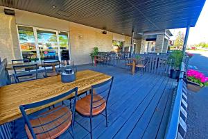 a wooden deck with a table and chairs on a restaurant at Hotel-Motel La Difference in Sainte-Marie