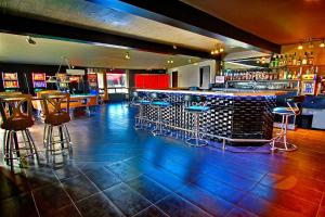 a bar with stools and a counter in a room at Hotel-Motel La Difference in Sainte-Marie