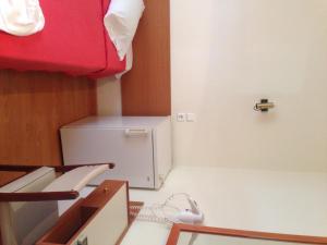 a small white refrigerator in a room with a red ceiling at Noufara Hotel in Kamena Vourla +47 photos
