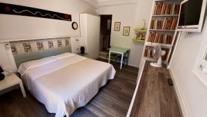 a bedroom with a white bed and a book shelf at Residence Al Lago in Castiglione del Lago