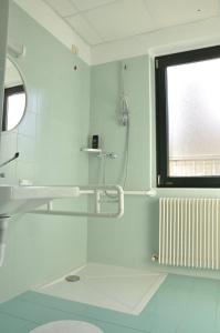 bagno bianco con doccia e finestra di Ex Latteria di Platischis a Taipana