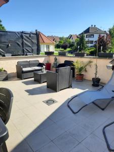 eine Terrasse mit Stühlen und Tischen auf dem Dach in der Unterkunft Au bonheur des hirondelles in Kirrwiller