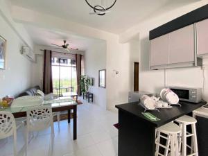 - une cuisine et une salle à manger avec une table et des chaises dans l'établissement Maz Stayhouse, à Alor Setar