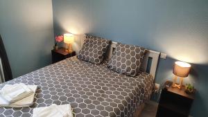 a bedroom with a bed and two lamps on tables at Maison, jardin, barbecue et vélo classé 3 étoiles in Dives-sur-Mer