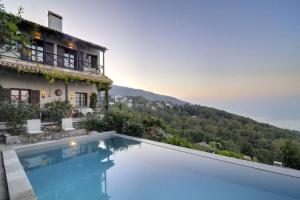 a villa with a swimming pool in front of a house at Bird's eye-view in Zagora