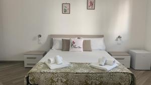 una camera da letto con un grande letto con asciugamani di Casa di Nonna Checca a Leuca