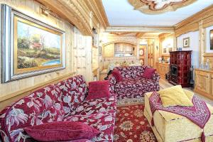 een woonkamer met een bank en een stoel bij Luxury Apt Dolomites 2 in Pinzolo