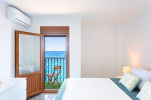 a bedroom with a bed and a view of the ocean at Apartamento El Palmer in Almería