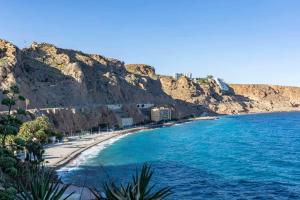 a view of a beach next to a mountain at Apartamento El Palmer in Almería