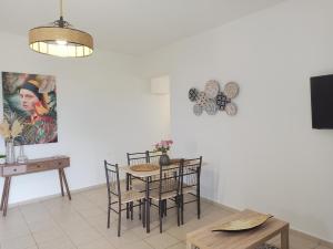 uma sala de jantar com mesa e cadeiras e uma televisão em Sea melody apartments em Stavromenos