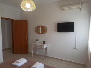 um quarto com uma mesa e uma televisão na parede em Sea melody apartments em Stavromenos
