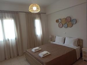 een slaapkamer met een bed met twee handdoeken erop bij Sea melody apartments in Stavromenos