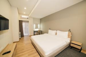 ein Schlafzimmer mit einem großen weißen Bett und einem Fernseher in der Unterkunft Solutel apartments-32 in Bischkek