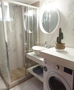 a bathroom with a sink and a washing machine at Sea melody apartments in Stavromenos