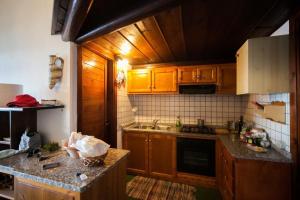 a kitchen with wooden cabinets and a counter top at Appartamento Sole e Mare in Santa Margherita di Pula +37 photos
