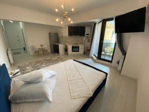 a large white bed in a room with a kitchen at Luxury Studio Solid Butoaie in Mamaia
