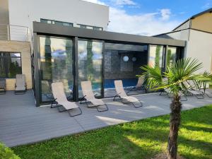 a deck with white chairs and a pool at Hotel Padesul in Făget