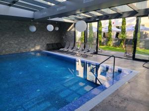 a swimming pool with chairs in a house at Hotel Padesul in Făget