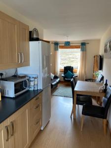 cocina con microondas y mesa con sillas en Apartment 2, Craigmore, Upper Baila, Lerwick en Lerwick