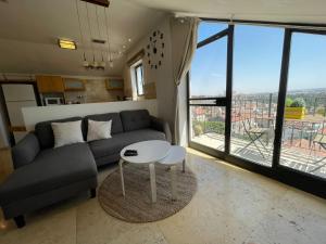 een woonkamer met een bank en een tafel bij Gorgeous Penthouse // Market Location // Panoramic in Jeruzalem