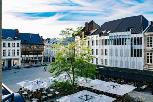 une place de la ville avec des tables et des parasols blancs dans l'établissement City apartment 3 BEDROOM, KITCHEN, WIFI, WORKSPACE, COFFEE, Central, à Hasselt