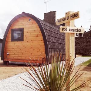 un petit bâtiment avec un panneau devant lui dans l'établissement Le Domaine de Pivette Chambre climatisée et insolite avec terrasse privative, à Avranches