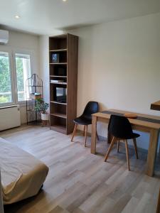sala de estar con mesa y 2 sillas en appartement entre Mer et Corbières, en Cuxac-dʼAude