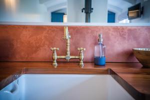 La salle de bains est pourvue d'un lavabo et d'une bouteille sur un comptoir. dans l'établissement Inglewood Shepherd's Huts, à Penrith