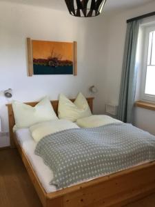 1 dormitorio con cama de madera y almohadas blancas en Ferienwohnung Neureiter en Golling an der Salzach