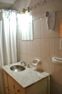 a bathroom with a sink and a shower at Hostel Ruta76 in Sierra de la Ventana