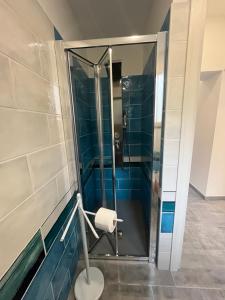 a glass shower in a bathroom with blue tiles at La Ginestra in Giardini Naxos +43 photos