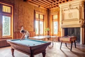 un homme jouant au billard dans une salle avec un billard dans l'établissement Château Le Boisrenault, à Buzançais