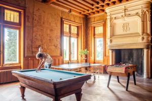 a man playing pool in a room with a pool table at Château Le Boisrenault in Buzançais