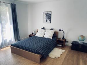 - une chambre dotée d'un lit avec une couverture bleue dans l'établissement Oak'Wood, à La Queue-lès-Yvelines