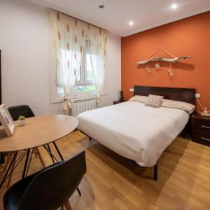 a bedroom with a large bed and a table at El Gato Gordo - bike & surf house in Cudillero