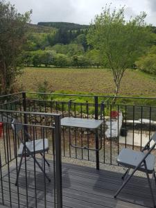 2 chaises et une table sur une terrasse avec un champ dans l'établissement Quarvue Loft, à Ó Méith