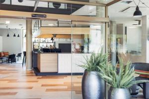a bar in a restaurant with two potted plants at harry's home Telfs hotel & apartments in Telfs +26 photos