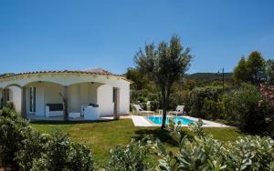 une villa avec un jardin et une piscine dans l'établissement Limone Beach Resort, à Castiadas