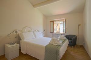 una camera con un letto bianco e una sedia di Giorgio Ponte Vecchio Apartment a Firenze