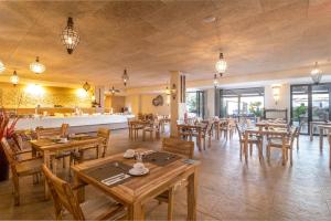 a restaurant with wooden tables and wooden chairs at El Cortijo de Zahara by QHotels in Zahara de los Atunes