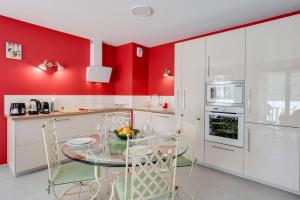 uma cozinha com paredes vermelhas e uma mesa e cadeiras de vidro em Emergence - Apartment 1 bedroom 2-4 pers Garage and Terrace em Annecy