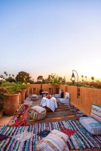 un patio con almohadas, mesa y sillas en Riad Anya & SPA, en Marrakech