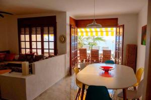 a living room with a table and a table and chairs at Villa Jo - stunning front line beach house. in L'Ametlla de Mar