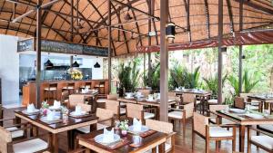 a restaurant with wooden tables and chairs and a kitchen at Kata Ocean View condominium by Lofty in Kata Beach