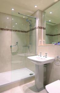 a bathroom with a sink, toilet and shower at Macdonald Kilhey Court Hotel & Spa in Wigan