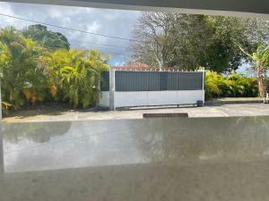 a white fence in front of a house at Gîtes de Corneille, Bungalow Little Banania in Le Moule