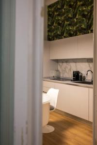 kuchnia z białymi szafkami i białym krzesłem w obiekcie La Dépendance Hotel w mieście Noto