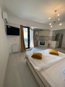 a large white bedroom with a large bed with yellow pillows at Luxury Studio Solid Butoaie in Mamaia +128 photos