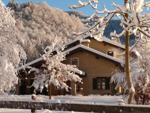 a house covered in snow in front of trees at B&B Notte Stellata in Gaiola